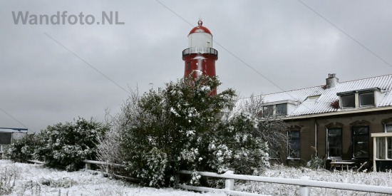 Kleine vuurtoren in de sneeuw