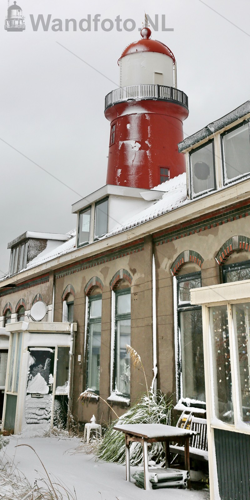 Kleine vuurtoren in de sneeuw