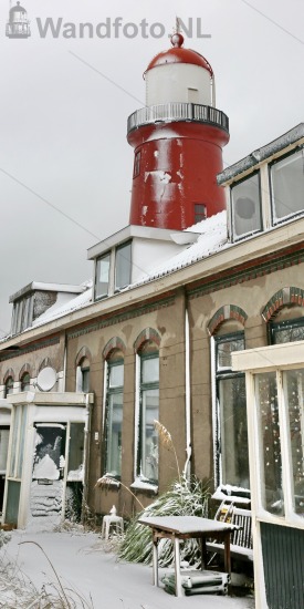 Kleine vuurtoren in de sneeuw